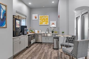 Community kitchen with gray cabinetry and artwork